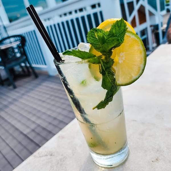 A refreshing Dunmire’s cocktail with lime, lemon, and mint, on a patio table.